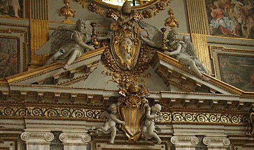 Indgangsvæggen i Kirkens hovedskib - våbenskjold for Pave Benedikt XIV nederst og for Pave Clemens VIII øverst